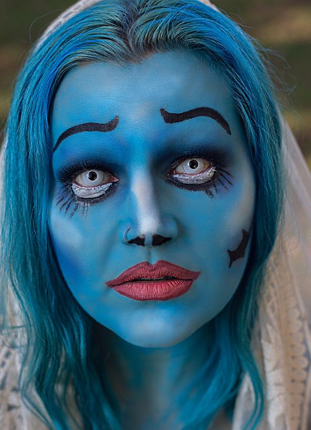 Blue-skinned bride character with dark brows and red lips