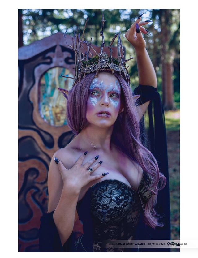 Gothesque page: crowned model with jewel face paint by a carved wooden screen