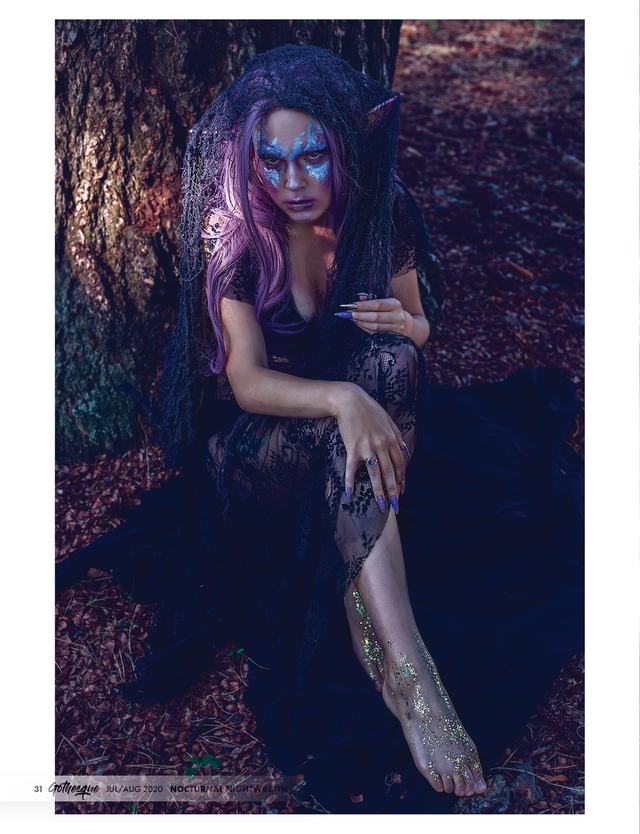 Gothesque page: lilac-haired model seated at a tree