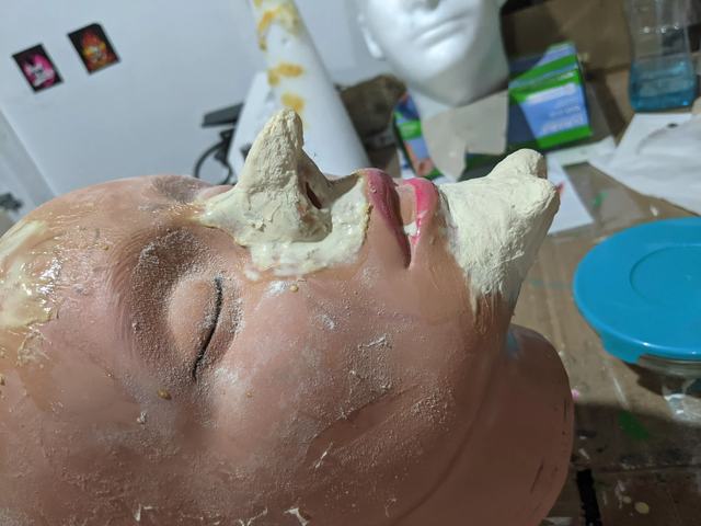 Latex-and-cotton nose and chin pieces built up on a practice head
