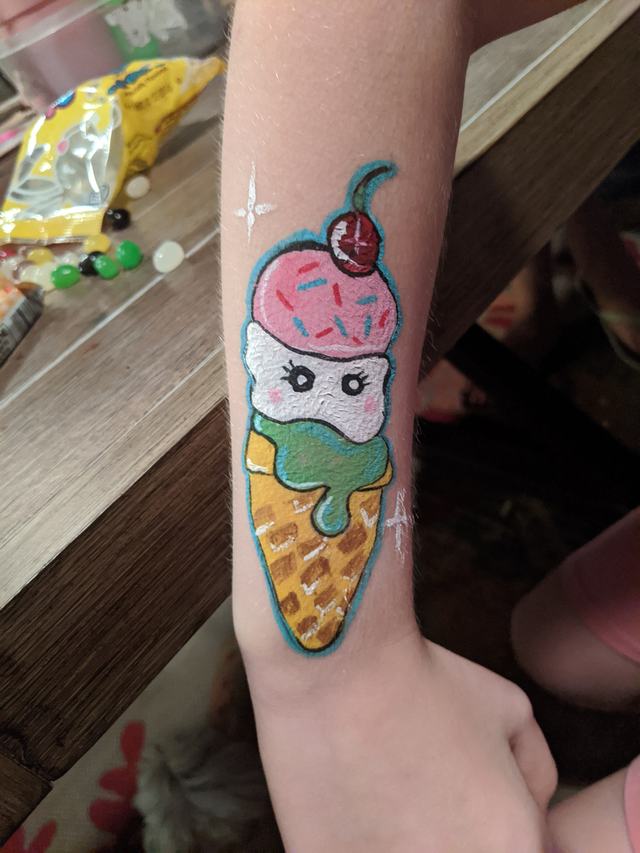 Ice-cream cone with a cherry, painted on a forearm