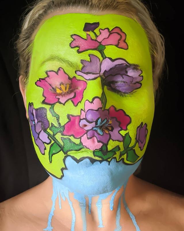 Whole face painted as a bold-outlined floral in pink, lavender and lime, inspired by a Peter Max print