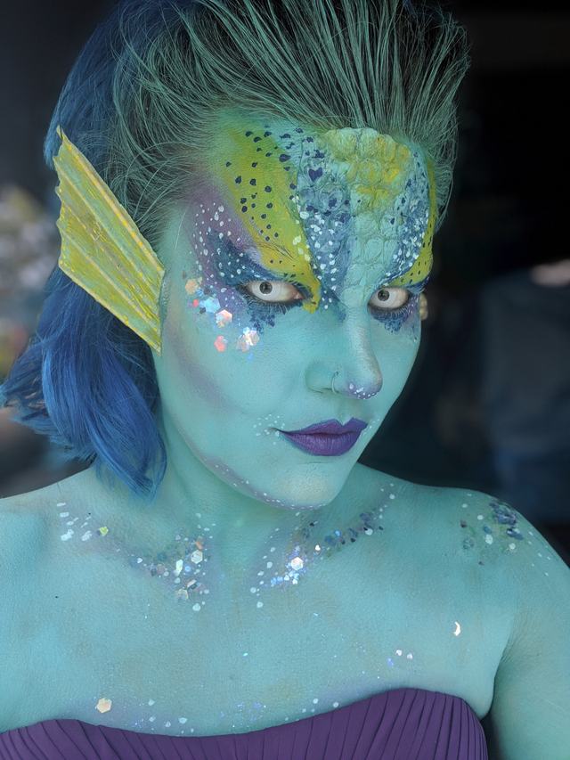 Sea-creature look: glittering blue-green skin with fins at the temples