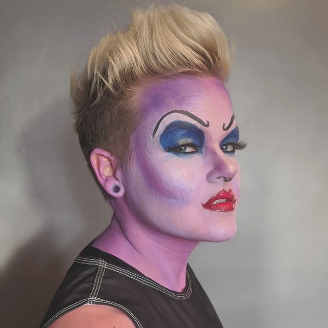 Lavender-skinned sea-witch character with dramatic blue lids