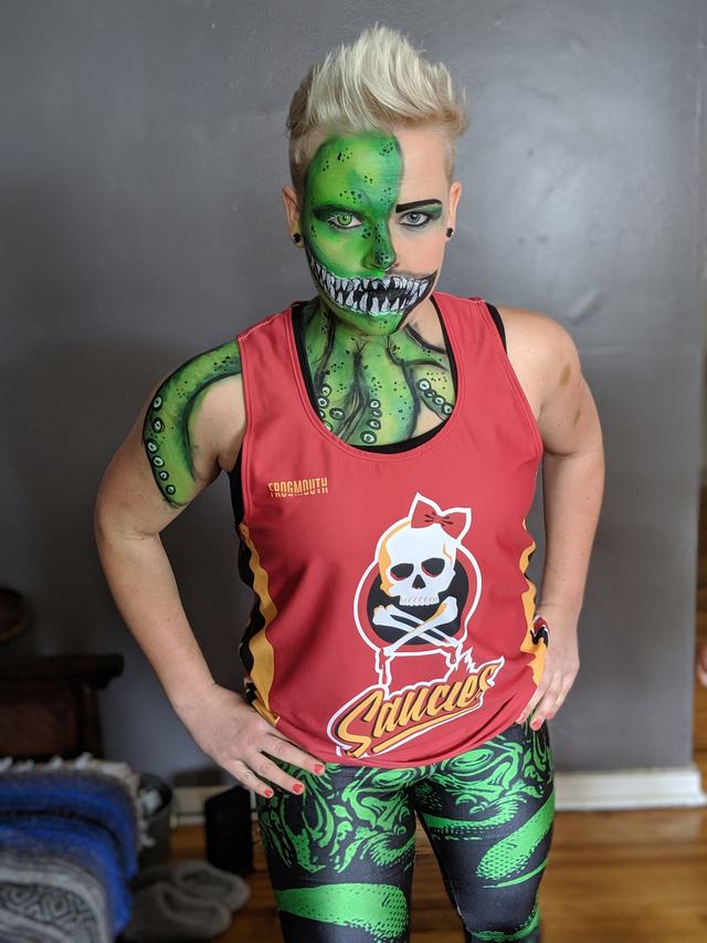 Green serpent painted coiling across the face, neck and arm
