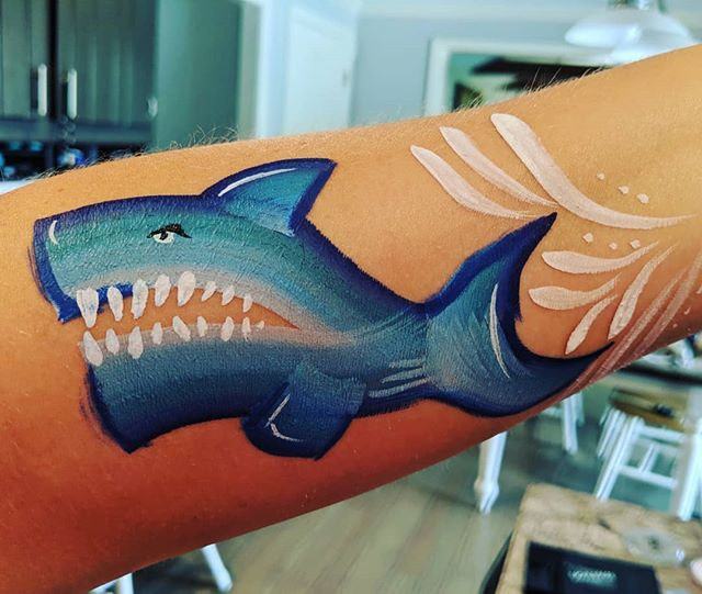 Shark with open jaws swimming along a forearm