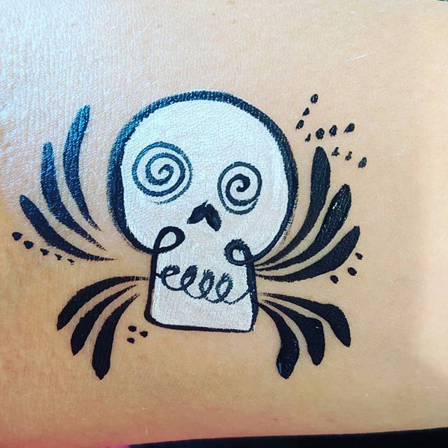 Black-and-white swirl-eyed skull with flourishes