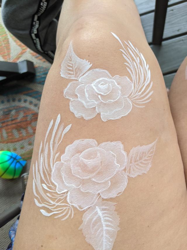White roses and wings painted on a hand and wrist